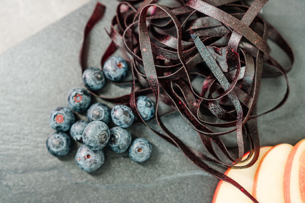 Fruchtschnüre Heidelbeere mit Heidelbeeren und Äpfel auf einer Schieferplatte